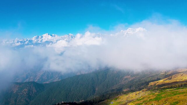 Aerial drone hyperlapse timelapse showing snow covered Himalayan peaks with clouds rolling in front shot at Chopta for Tungnath trek in Uttarakhand India