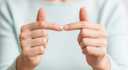 Naklejka premium Close-up of a person holding two fingers for a finger heart gesture
