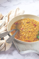 Delicious bowl of flavorful lentil soup with spices and herbs served in a rustic setting