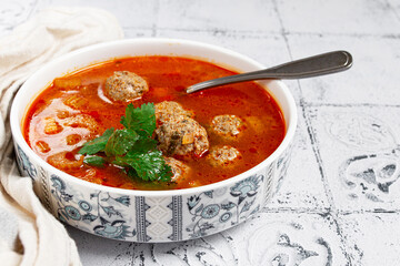 Romanian soup with meatballs, vegetable soup with meatballs, tiled table, homemade, no people,
