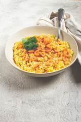 risotto with shrimp, in a bowl, on a textured surface, with a side dish of fresh coriander, homemade, no people,