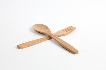 Spoons and forks made of teak wood isolated on white background. Traditional cutlery with a rustic feel