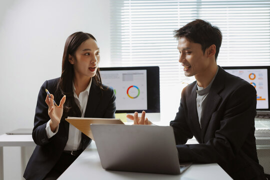 Young business professionals discussing financial data and marketing strategy in a modern office environment