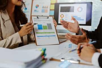 Business professionals collaborating, discussing financial planning, analyzing charts and reports in a modern office environment
