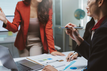 Professionals collaborating on project strategy, reviewing financial reports and charts in a modern office environment