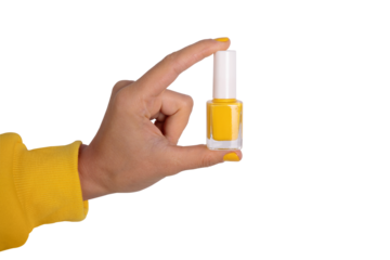 Close-up of a hand holding a bottle of yellow nail polish on transparent. Bright, modern concept for beauty, cosmetics, and manicure themes.