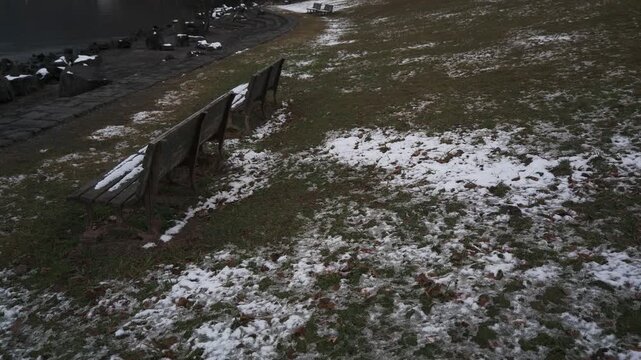 薄っすらと雪が被った湖畔の公園ベンチ