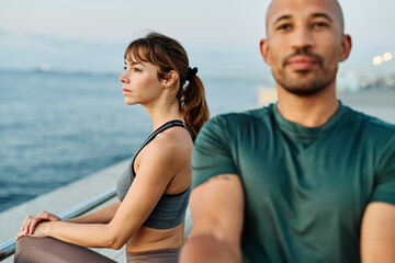 Fototapeta premium Portrait os a happy beautiful couple exercising and stretching outdoors