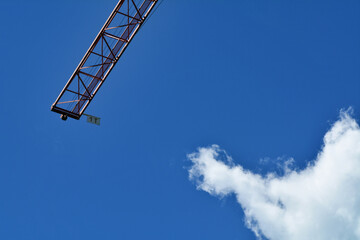 Fototapeta premium Una gru in un cantiere edile con il cielo blu sullo sfondo.