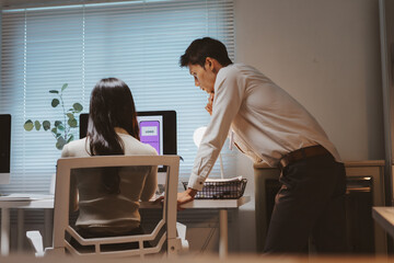Two design colleagues working together in an office, brainstorming creative ideas and developing user interface for mobile application