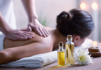 Escena de masaje relajante que evoca conexión corporal, cuidado emocional y una cálida atmósfera de bienestar. Una persona, tumbada boca abajo, recibe un masaje de espalda con aceites en un ambiente