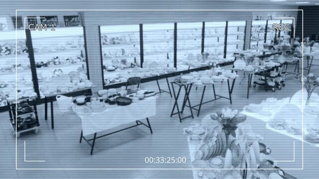 Wide no people security camera CCTV of interior of tableware showroom, with assorted merchandise arranged on tables and shelves, before opening for customers