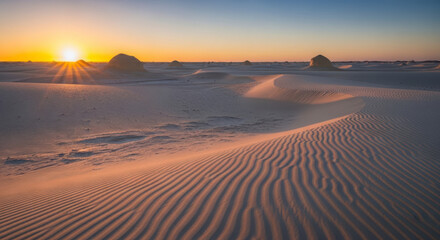 Golden hour sunset over a serene white desert landscape with rippled sand dunes
