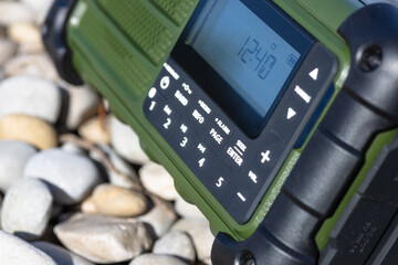 Rugged Handheld Radio With Digital Display On Pebble Ground For Fieldwork