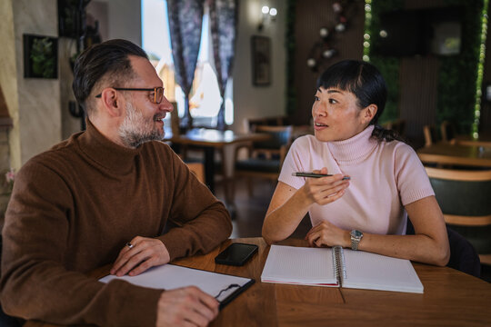 Business colleagues meeting, discussing ideas and planning strategy in cafe