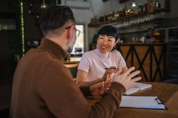 Business colleagues having informal discussion during restaurant meeting