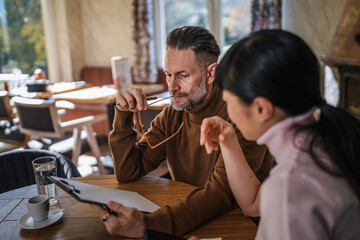 Concerned business colleagues looking at tablet during meeting
