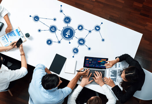 A diverse team collaborates in a modern office setting, utilizing digital tools and engaging in strategic planning and data analysis for effective business outcomes. Amity - Powered by Adobe