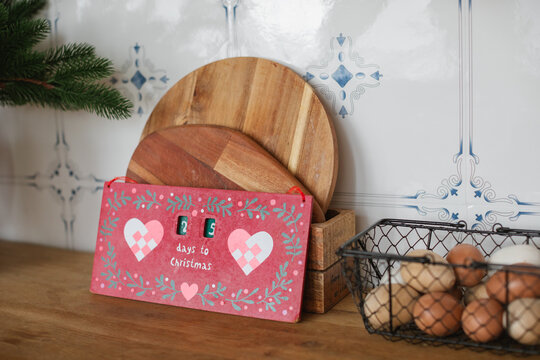 Close-up of a Christmas countdown calendar on a kitchen worktop next to a basket of eggs