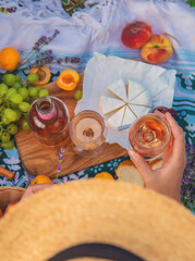 A woman drinks wine in a lavender field. Selective focus.