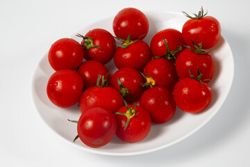 Plate with tomatoes on white