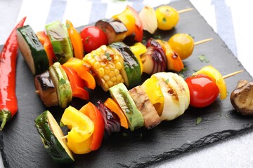 Skewers with tasty grilled vegetables on light table, closeup