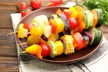 Skewers with tasty grilled vegetables on wooden table, closeup