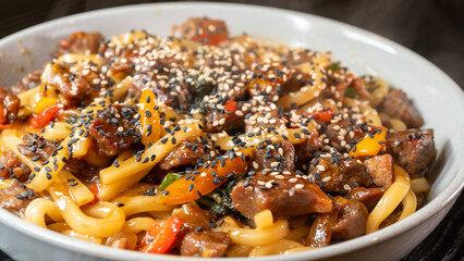 Smoking hot beef udon with broccoli, onions, and bell peppers in a beautiful bowl. Rich broth, fresh vegetables, perfect for Japanese cuisine lovers.