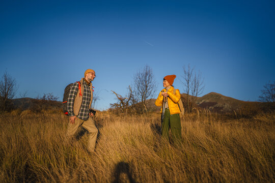 Couple exploring nature while hiking with backpacks and camera