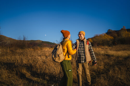 Couple interacting and talking during autumn nature hiking adventure