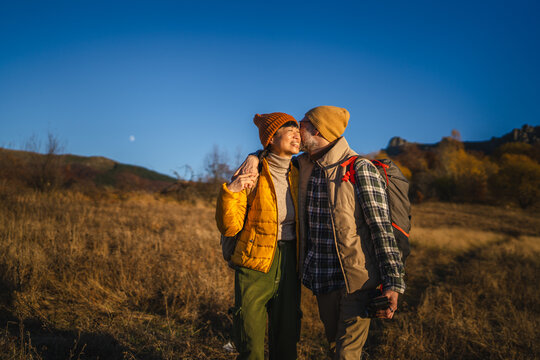 Senior couple enjoying autumn hike outdoors together smiling