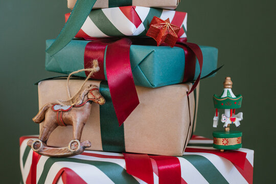 Close-up of a stack of five wrapped Christmas gifts with Christmas decorations