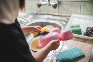 A little girl washing dishes