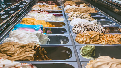 Assorted artisan ice cream display in modern gelato shop