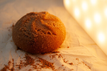 Freshly baked cookie on parchment paper with loose powder.