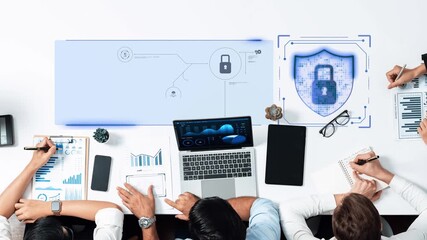 A collaborative workspace showing professionals engaging in cybersecurity strategy development with laptops, charts, and a digital lock symbol representing data security. Raster - Powered by Adobe