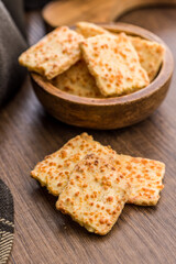 Crunchy salted crackers on wooden table.