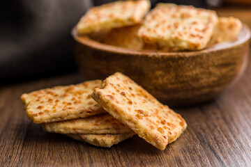 Crunchy salted crackers on wooden table.