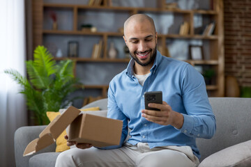 Happy man unboxing online shopping package at home