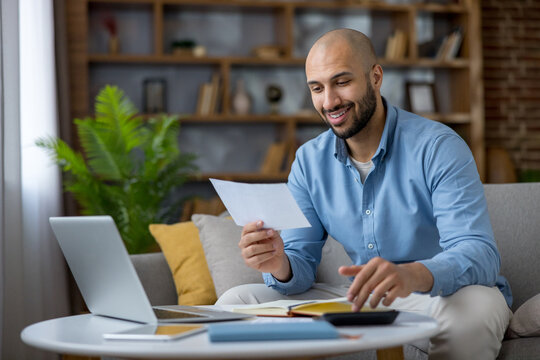 Man calculating home finances, paying bills remotely smiling