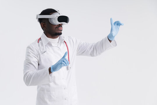 African male doctor wearing vr headset with gloves interacting in virtual space. Online virtual reality future technology concept - Powered by Adobe
