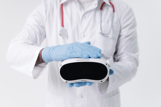 Closeup African male doctor demonstrating virtual reality headset in medical setting, white background