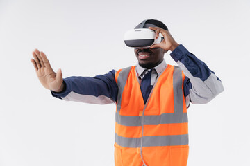 African male engineer using vr headset in safety vest for virtual reality industry experience, worker touching immersive display