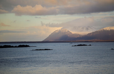 Snowy mountains above calm sea at sunset, Akranes, Iceland