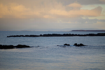 Calm coastal seascape with rocky islets at sunset, Akranes, Iceland