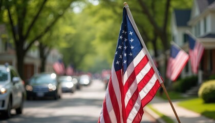 American flag waving during Memorial Day parade. Red white and blue stars stripes on display. Patriotism respect for veterans. Celebrating national holiday. Cars drive on road.