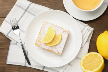 Tasty lemon bar with powdered sugar served on wooden table, flat lay