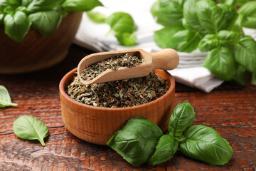 Dry basil leaves, fresh ones, bowl and scoop on wooden table, closeup