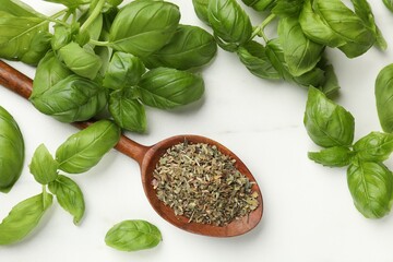 Dry basil leaves, fresh ones and spoon on light table, flat lay