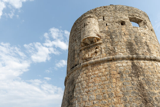 A weathered round tower fortress rises from rugged stone walls. Budwa old town